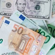 From above of chaotic pile of dollar banknotes and euro cash